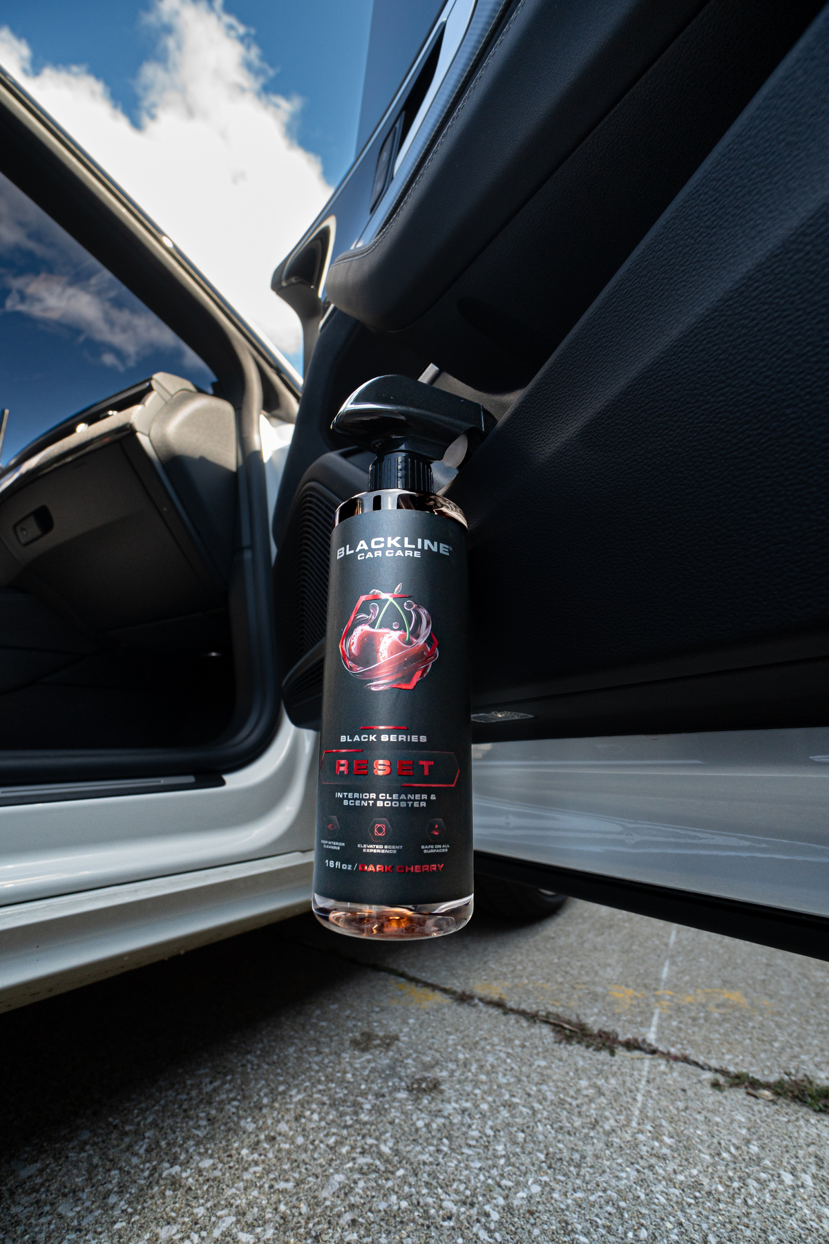 Blackline Reset scented interior cleaner being sprayed on a car interior surface