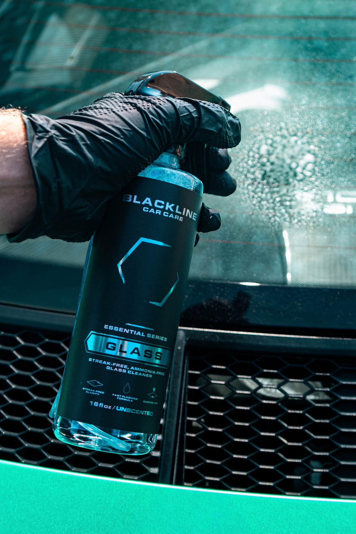Blackline Glass cleaner applied to a vehicle side window during interior detailing.