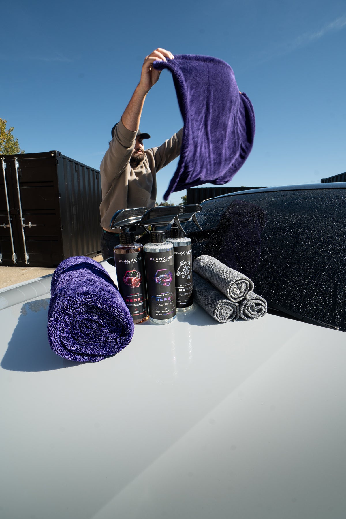 Blackline drying towel and Reset interior cleaner bundle on dark background, front view