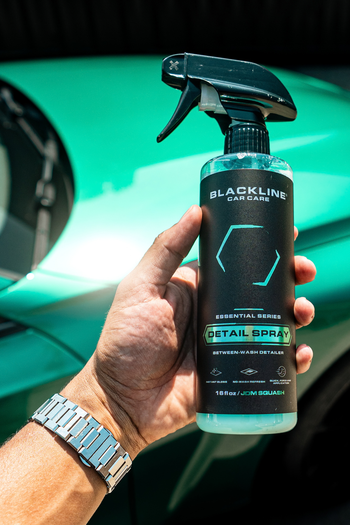 Blackline Essential Series Detail Spray black bottle on dark background.