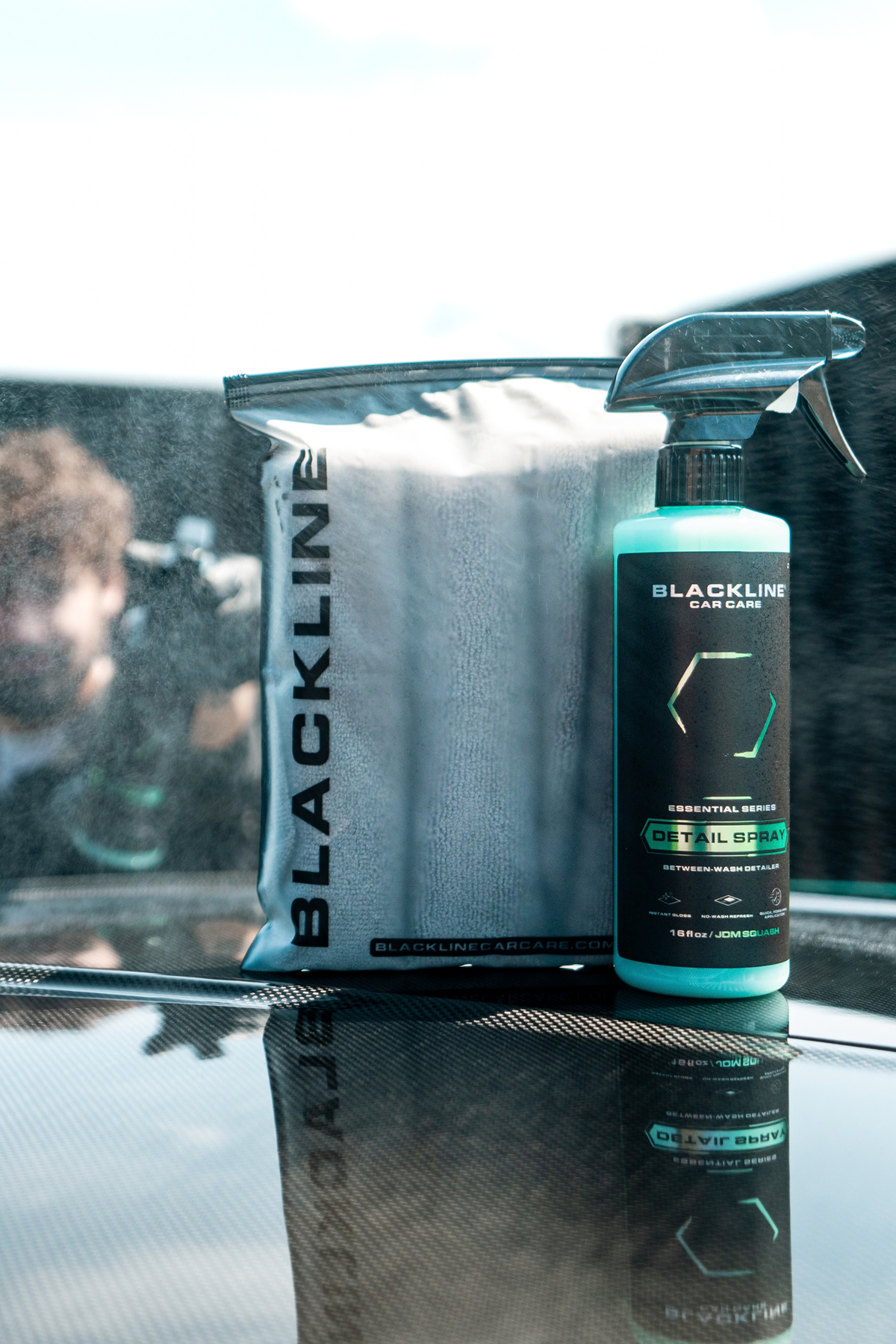 Blackline Detail Spray misted onto a car hood for quick surface refresh and gloss.