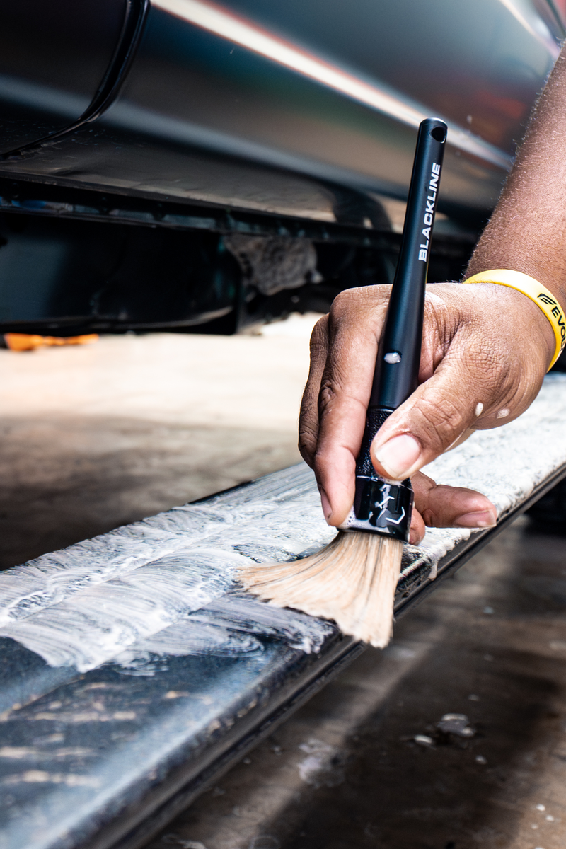 Boar's-hair brush being used to dust off air vents in a vehicle.