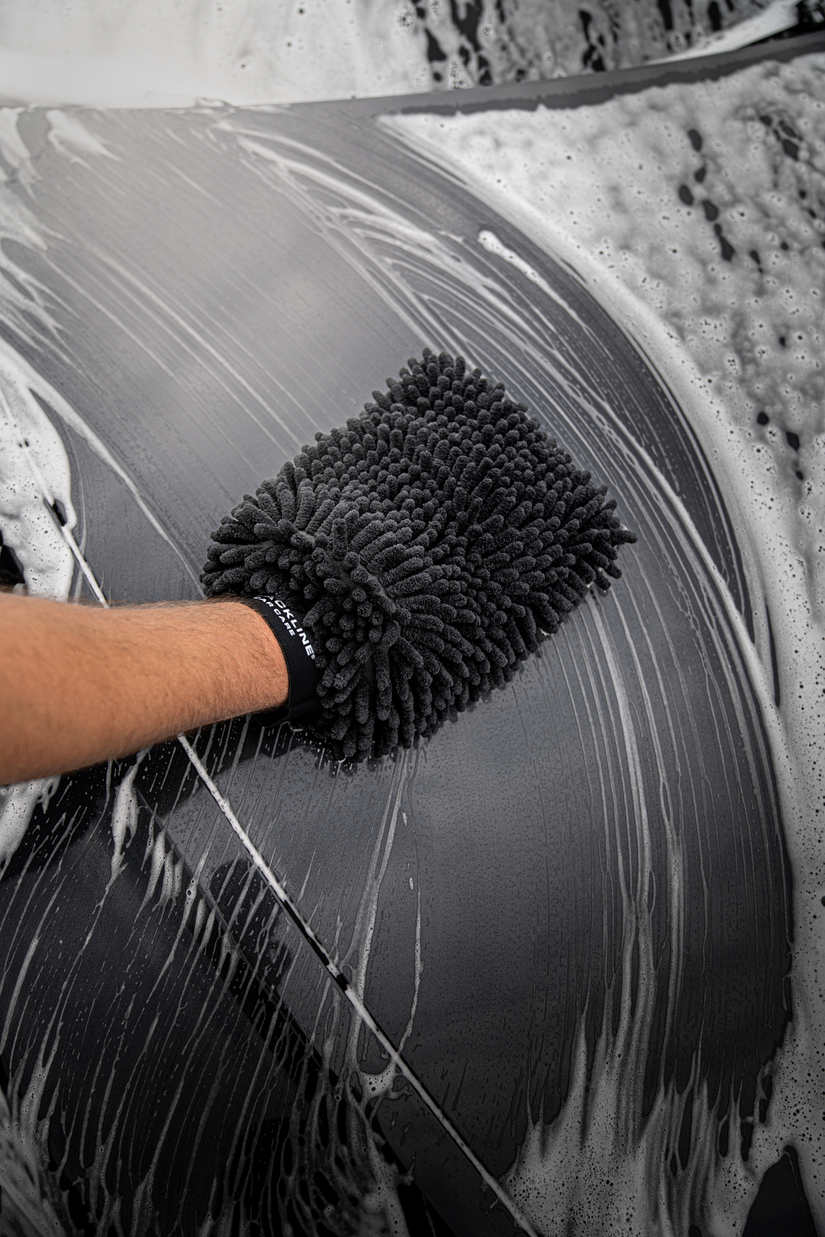 Blackline Chenille Wash Mitt loaded with foam being glided across a vehicle hood.