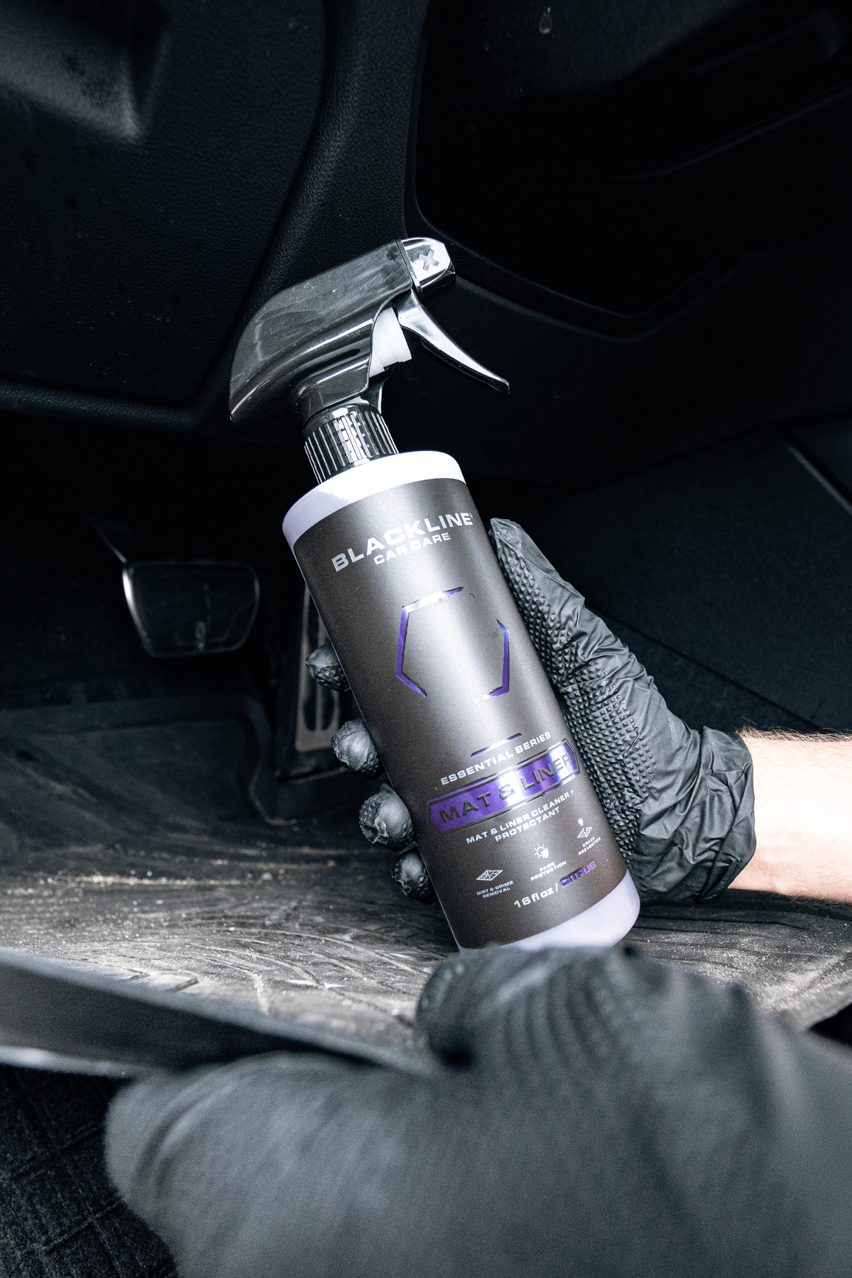 Blackline Essential Series Mat and Liner cleaner black spray bottle on dark background.