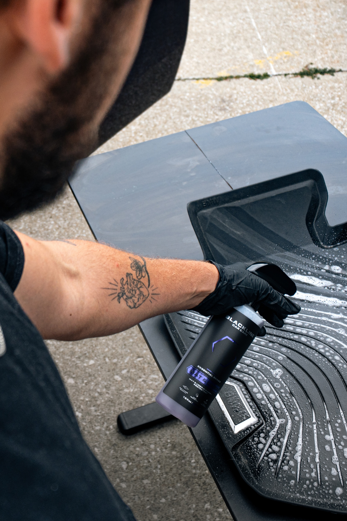 Blackline Mat and Liner cleaner sprayed onto rubber floor mats during interior detailing.