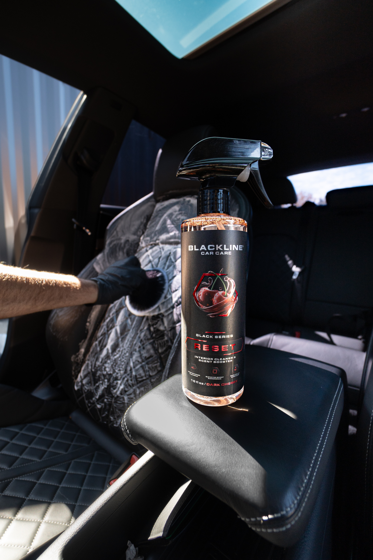 Blackline Reset interior cleaner applied to a car door panel during detailing