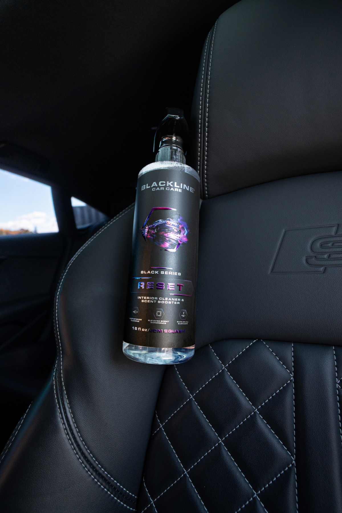 Blackline Reset interior cleaner in use on a car center console surface