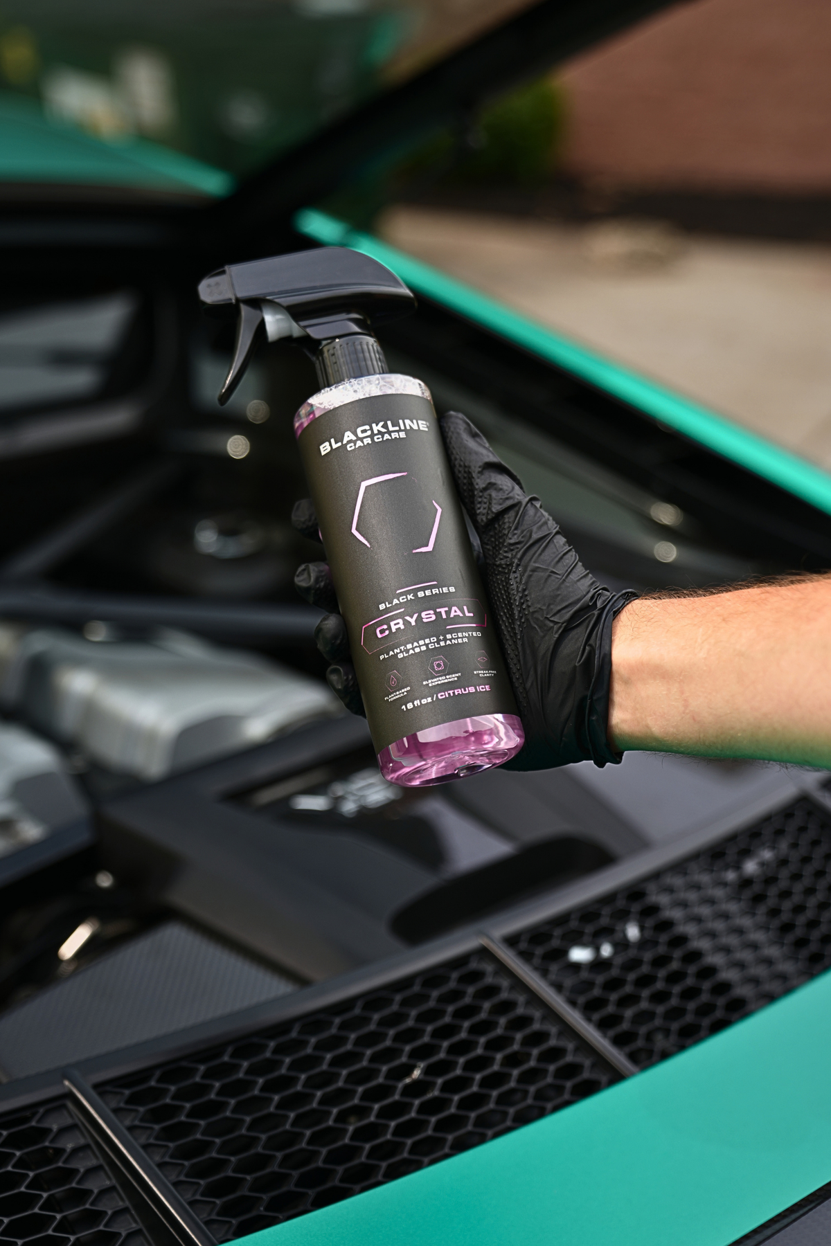 Blackline Reset scent-boosted interior cleaner spray bottle held in hand inside a vehicle
