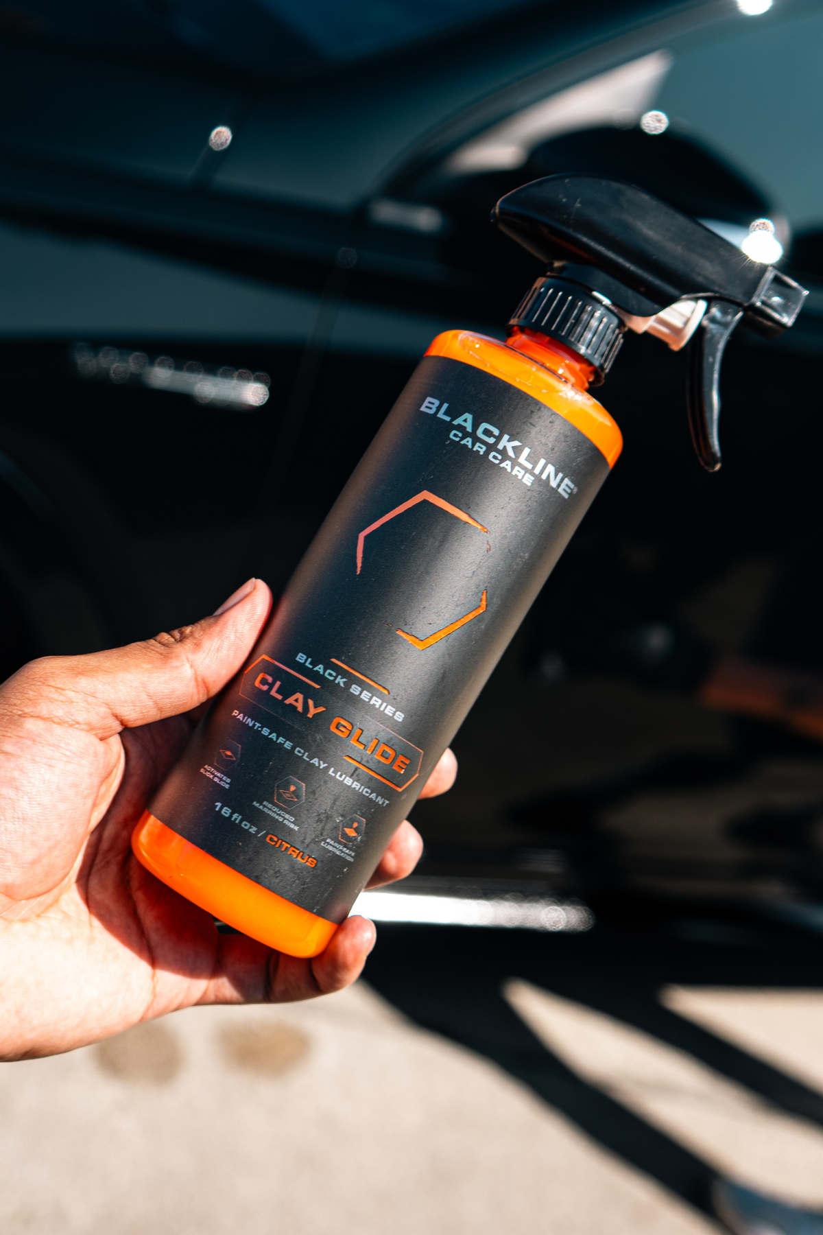 Blackline Clay Glide lubricant spray misted onto glossy car paint before clay treatment