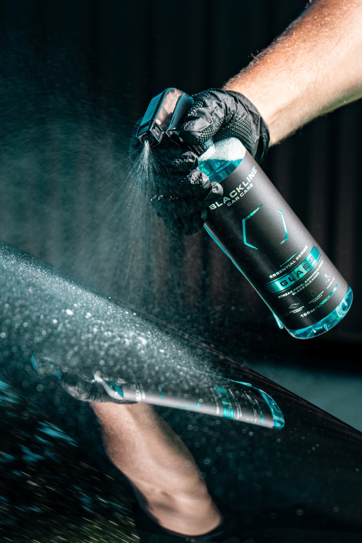 Blackline Essential Series Glass cleaner black spray bottle on dark background.