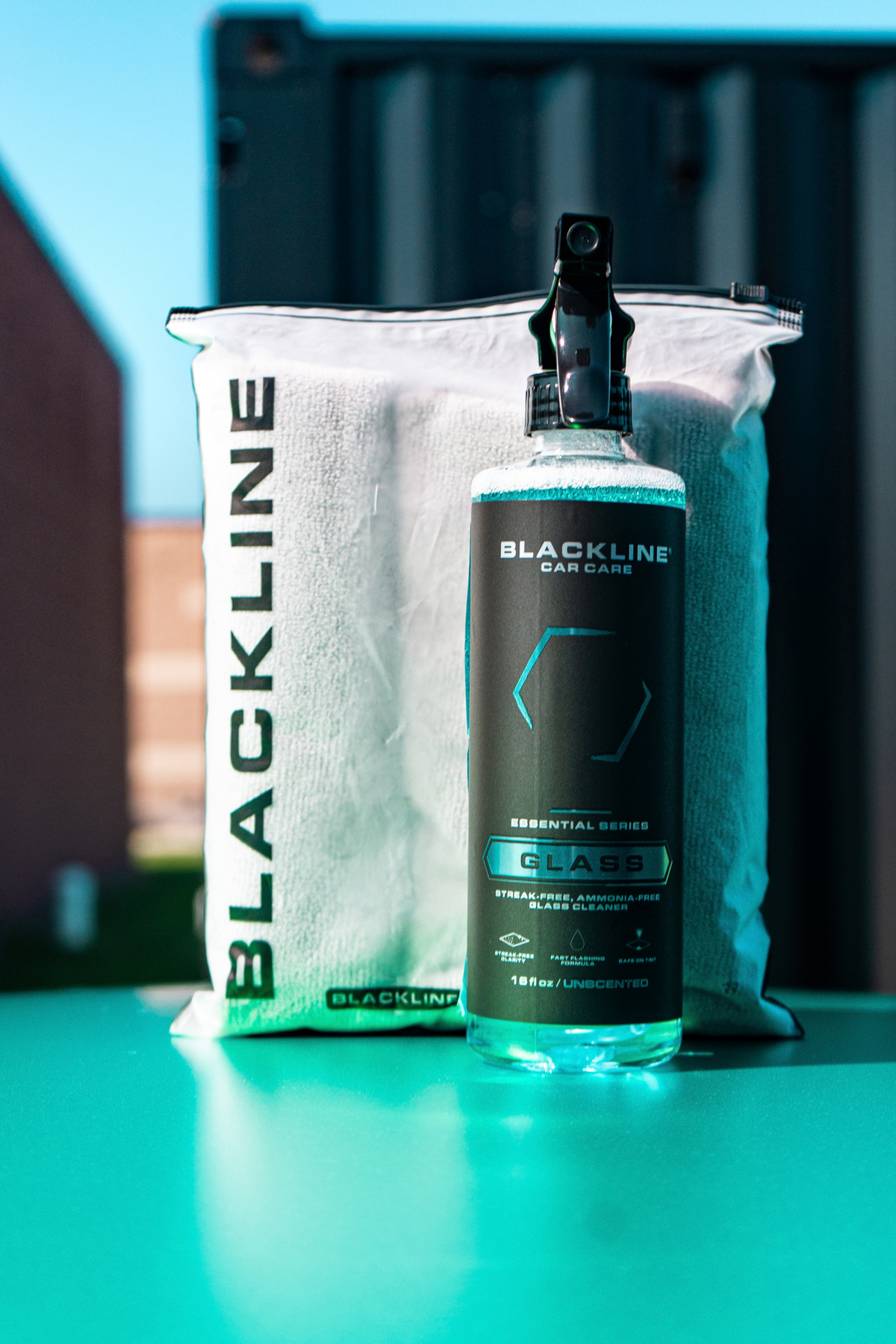 Microfiber cloth buffing Blackline Glass cleaner on a car mirror to crystal clarity.