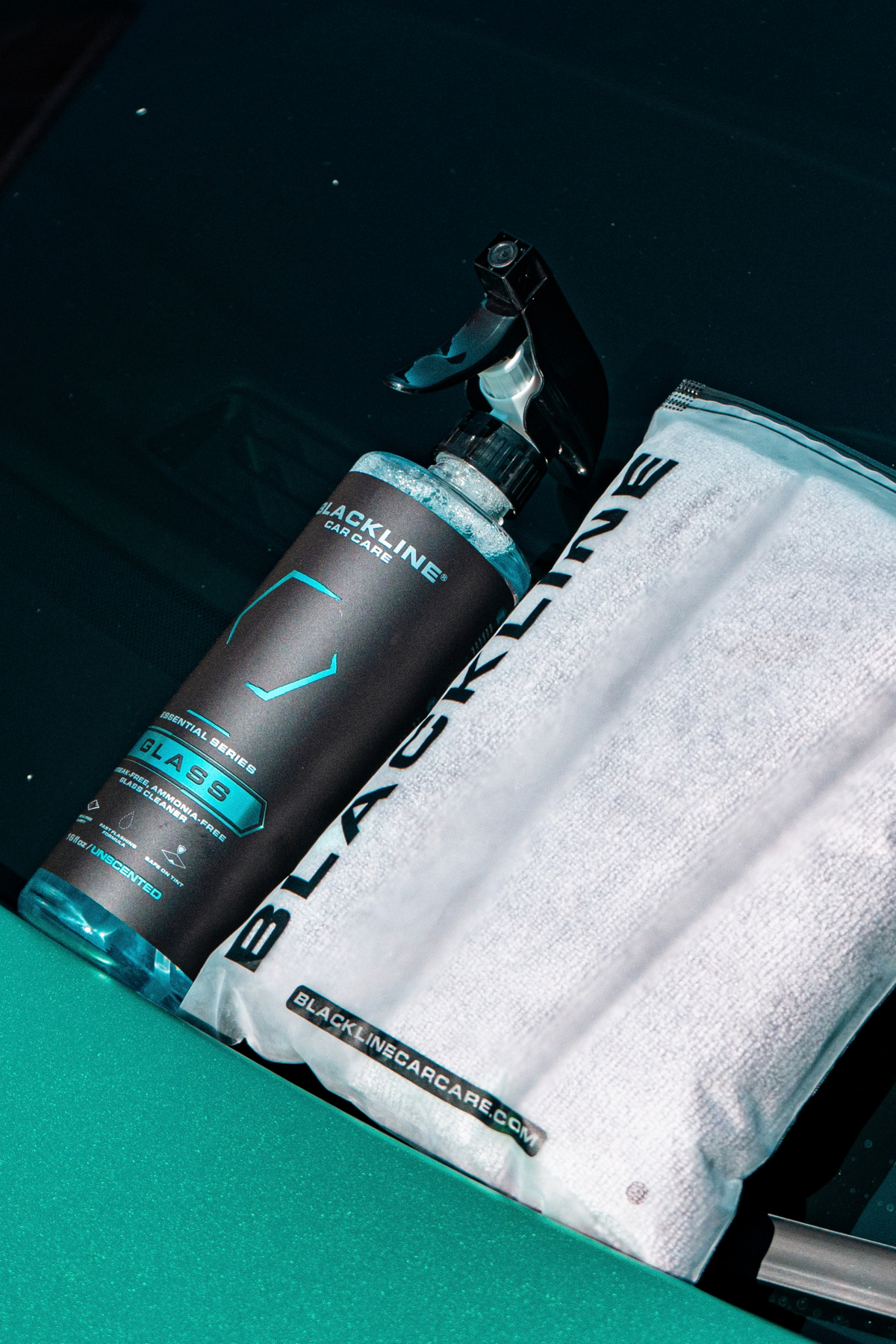 Blackline Glass cleaner in use on rear windshield of a vehicle during detailing.