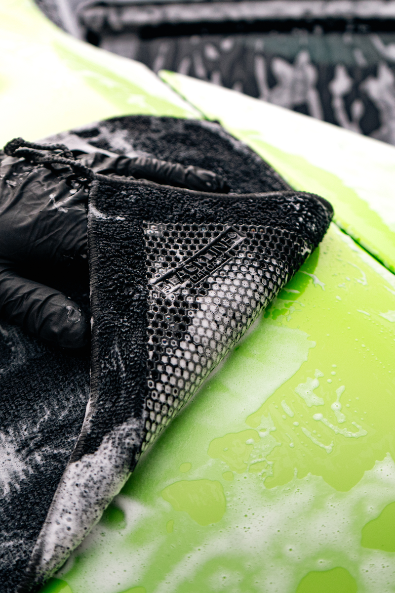 Blackline synthetic clay towel being used to decontaminate the paint on a McLaren sports car.