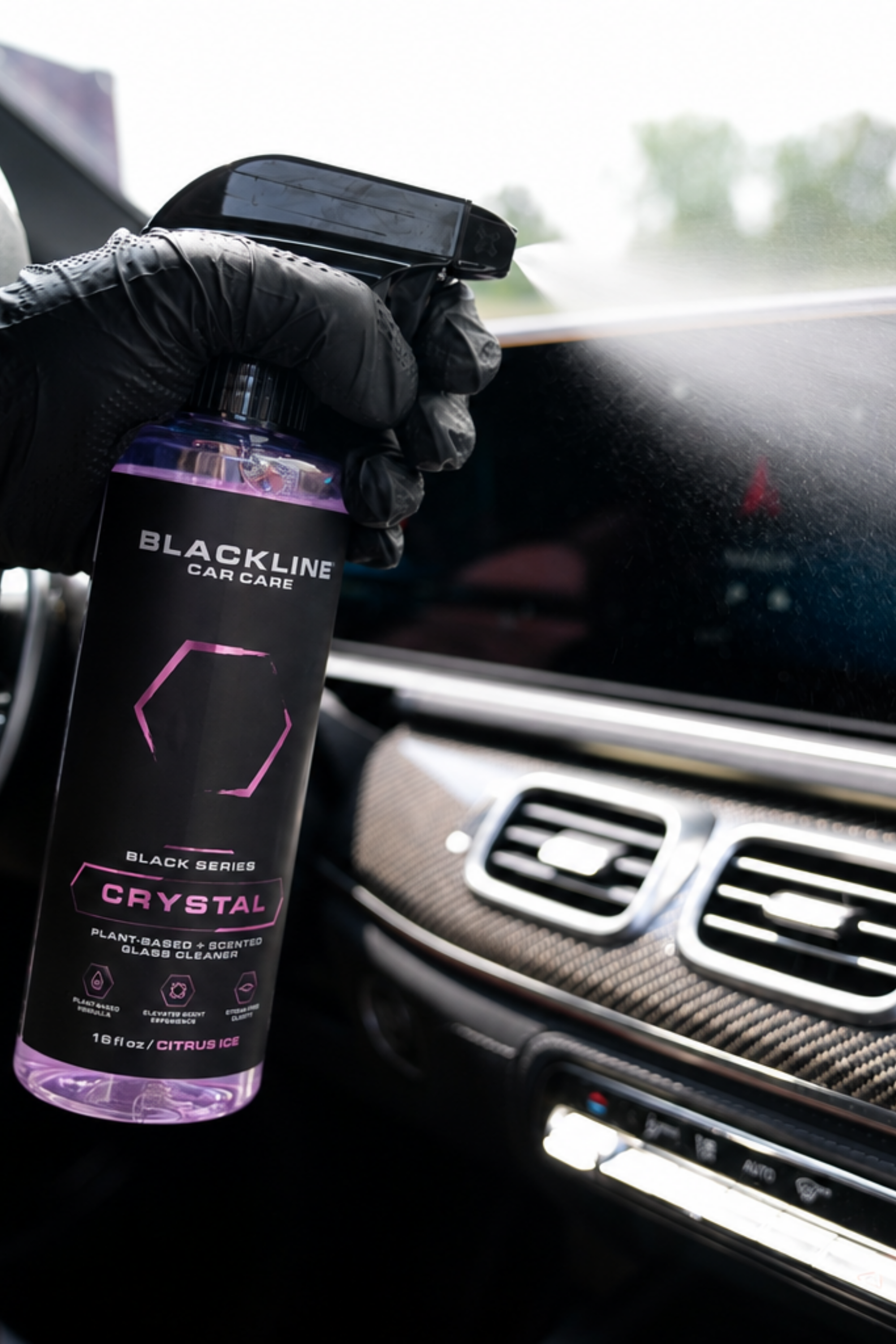 Blackline Crystal Glass Cleaner being applied to a car interior windshield