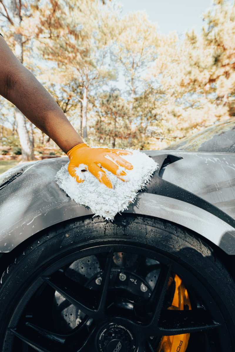 Blackline Wash Mitt soaked in soapy water and being used on a car panel.