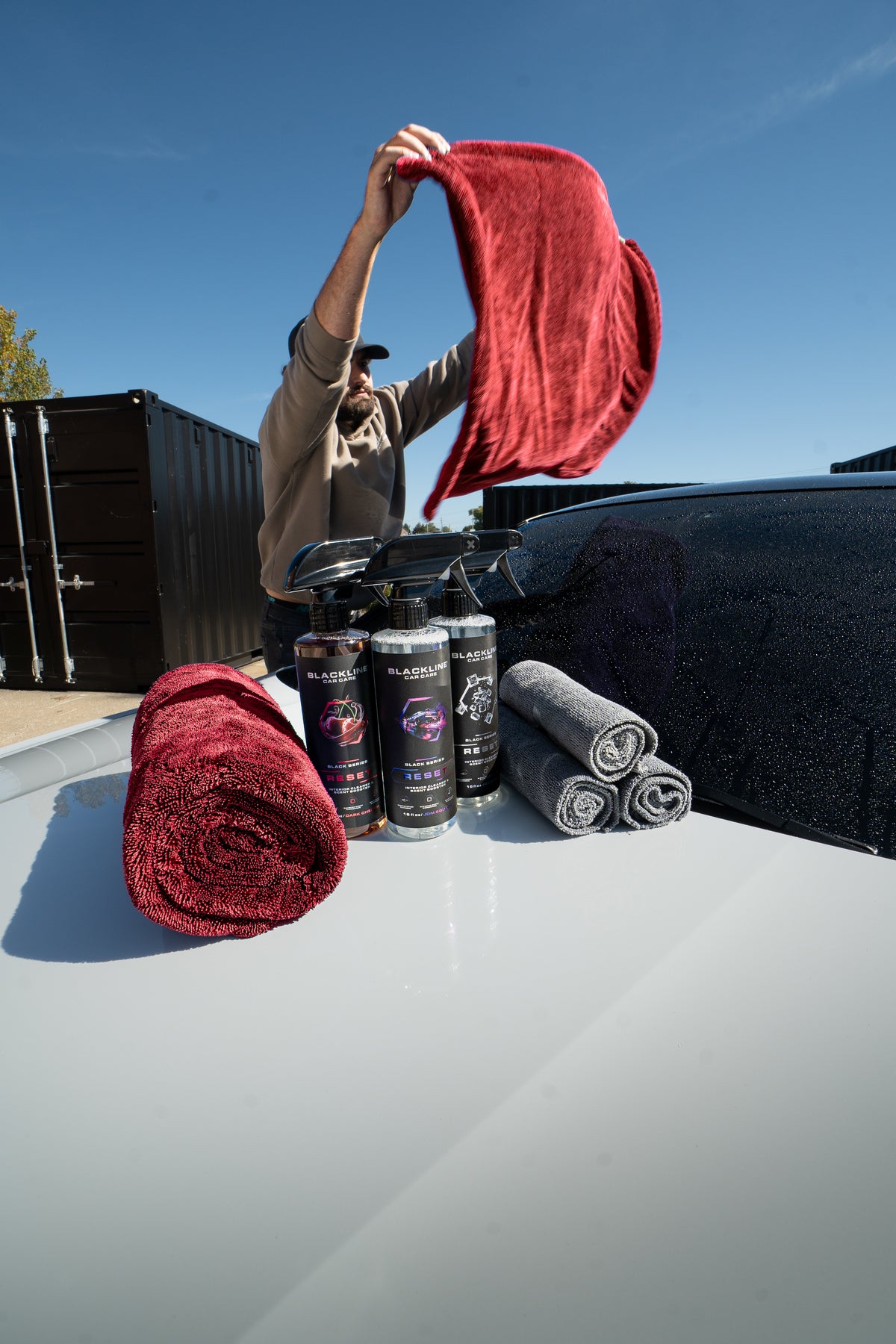Blackline drying towel and Reset interior cleaner bundle, side profile view on dark background