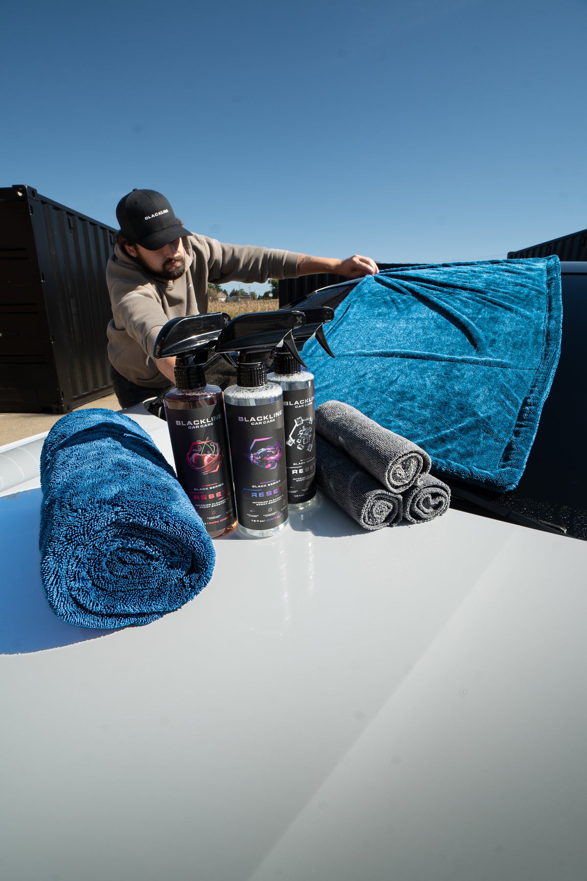 Blackline microfiber drying towel in use wiping down a vehicle panel streak-free