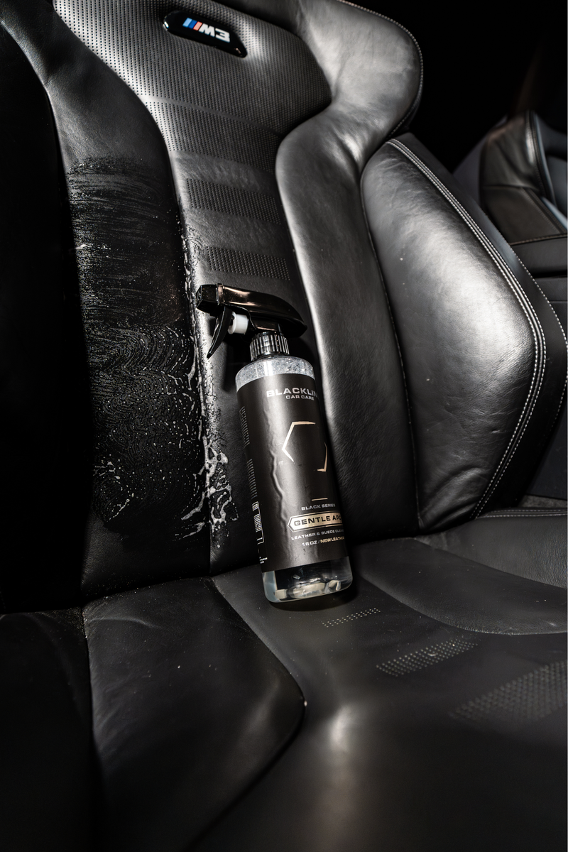 Blackline Gentle APC bottle resting on a leather car seat with a microfiber towel.